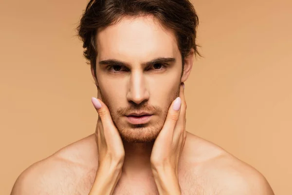 Woman touching face of young lover looking at camera isolated on beige — Stock Photo