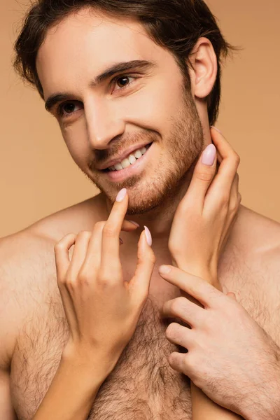 Mujer tocando cara de feliz joven amante aislado en beige - foto de stock