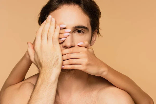 Woman obscuring face of young lover isolated on beige — Stock Photo