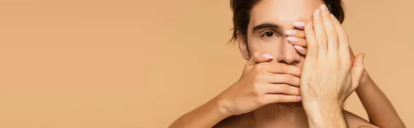 Mujer cubriendo la cara de hombre joven aislado en beige, bandera - foto de stock