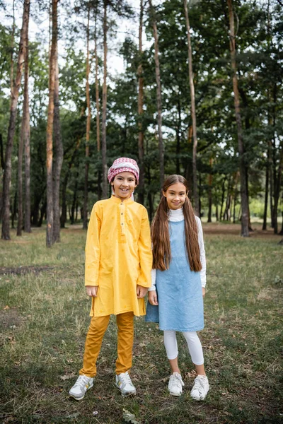 Lächelnde muslimische Kinder blicken im Park in die Kamera — Stockfoto
