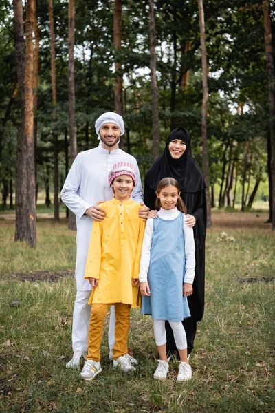 Arabian parents hugging smiling children in park — Stock Photo