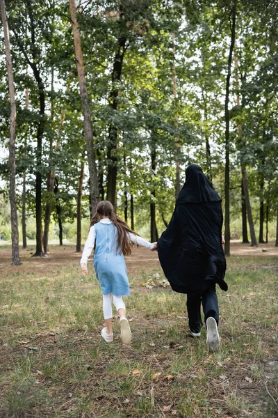 Vue arrière de la mère et de la fille arabes courant dans le parc — Photo de stock
