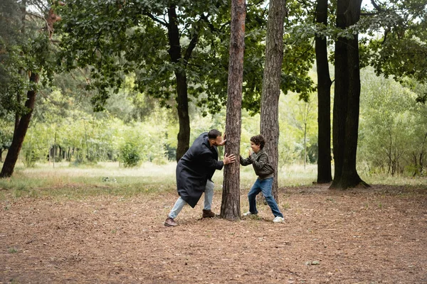 Arabian father playing with son near tree in park — Stock Photo