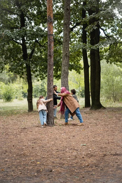 Familia musulmana jugando cerca de árboles en el parque de otoño - foto de stock