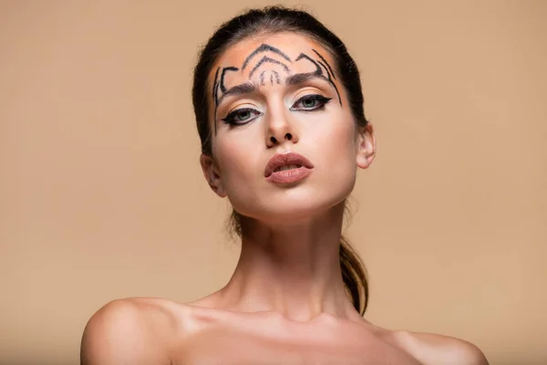 Hübsches Model mit Tiger-Make-up blickt vereinzelt in die Kamera auf Beige — Stockfoto