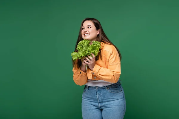 Femme heureuse avec surcharge pondérale tenant laitue fraîche isolée sur vert — Photo de stock