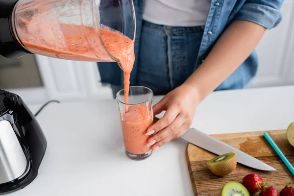 Cropped view of plus size woman pouring smoothie in kitchen — Stock Photo