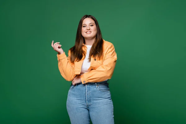 Young plus size woman smiling at camera isolated on green — Stock Photo