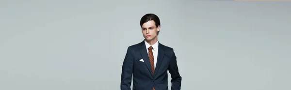 Young man in blazer and tie isolated on grey, banner — Stock Photo