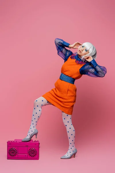 Asian pop art model in white wig posing near boombox on pink background — Stock Photo