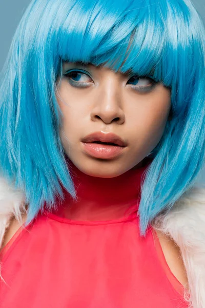 Portrait of asian woman in bright wig looking away isolated on blue — Stock Photo