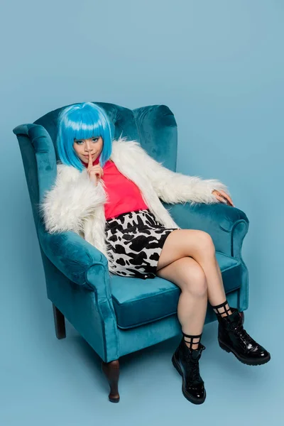 Sorridente donna asiatica in stile pop art mostrando gesto segreto su sfondo blu — Foto stock
