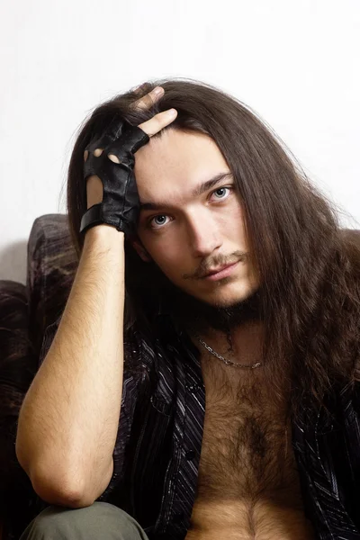 Retrato de un joven de pelo largo con camisa desabotonada — Foto de Stock
