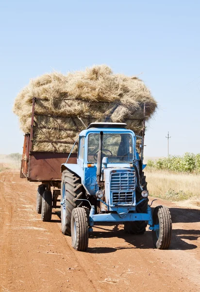 Tractor con carro de heno en una carretera de campo — Foto de Stock