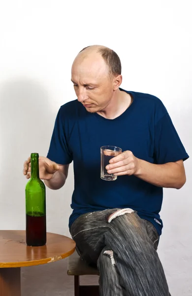 Homem com um copo e uma garrafa de vinho tinto — Fotografia de Stock