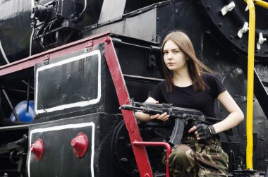 Motorun yanında silahlı poz kız