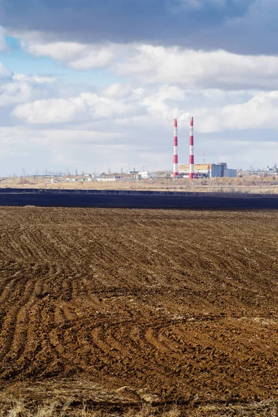 地平線に耕されたフィールドと火力発電所と秋の風景 写真はロシアのオレンブルクで撮影されました — ストック写真