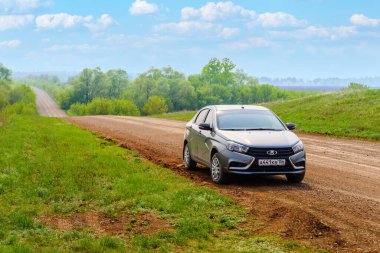 Orenburg bölgesi, Rusya - 10 Mayıs 2021: Araba Lada Vesta kırsal kesimde bir toprak yolda