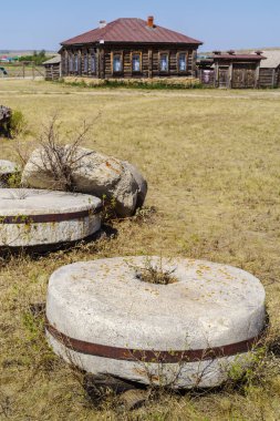 Arkaim, Chelyabinsk bölgesi, Rusya - 24 Ağustos 2021: Yel değirmeni ve Orenburg Kazak Müzesi ve mülklerinin eski değirmen taşları