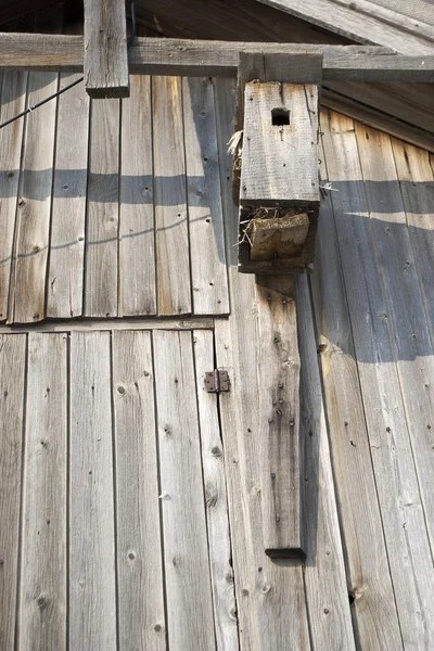 Birdhouse na frente de uma casa de madeira — Fotografia de Stock