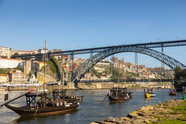 Dom Lus Köprüsü ve Porto 'daki tarihi şehir manzaralı Douro Nehri' ndeki geleneksel tekneler..