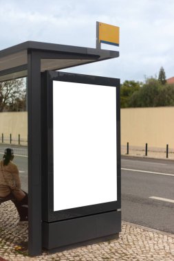 Lizbon 'da geniş, boş bir reklam paneli olan modern bir otobüs durağı. Yapının parlak, koyu bir çerçevesi var ve kaldırımda duruyor.