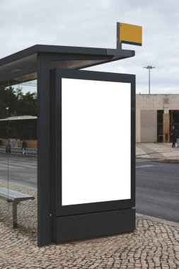 Lizbon 'da geniş, boş bir reklam paneli olan modern bir otobüs durağı. Yapının parlak, koyu bir çerçevesi var ve kaldırımda duruyor.