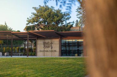 2025-11-30 Lisboa Portekiz - Yeşil çimenlik ve manzaralı bahçeyle çevrili Nestle modern şirket kampüs binası, sıcak doğal ışık ile altın saat sırasında fotoğraflandı