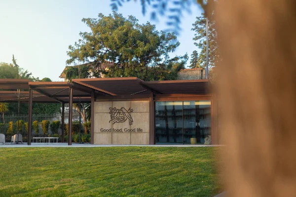 2025-11-30 Lisboa Portekiz - Yeşil çimenlik ve manzaralı bahçeyle çevrili Nestle modern şirket kampüs binası, sıcak doğal ışık ile altın saat sırasında fotoğraflandı