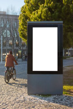 Güneşli bir günde boş beyaz ekranlı şehir reklam panosu Lizbon Portekiz 'de ağaçlar, binalar ve taş kaldırımlarla dolu bir açık alana yerleştirildi.