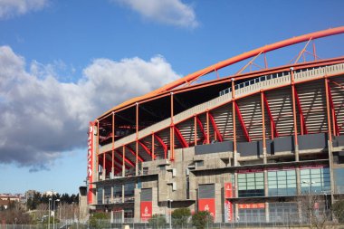 Lizbon, Portekiz 'de güneşli bir günde Lizbon, Portekiz' de açık bir gökyüzü altında kırmızı çelik yapısı ve oturma yerleriyle büyük ve modern bir futbol stadyumunun dış görüntüsü çekildi..