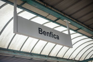 Benfica, Lizbon, Portekiz 2026-02-01: Benfica tren istasyonunun tavanında asılı Benfica yazısını imzalayın. Virajlı cam çatı altında çekilen şehir içi toplu taşıma altyapısı Lizbon 'daki günlük banliyö hayatını vurguluyor..