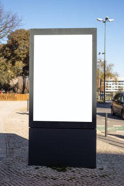 Fotokopi alanı olan bir kaldırımda boş dikey reklam panosu, markalaşma, pazarlama kampanyası ve poster tasarımı için ideal.