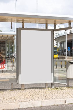 Otobüs durağındaki reklam panosunda boş beyaz bir yer var. Toplu taşıma araçları ve şehir geçmişi olan şehir sokakları.