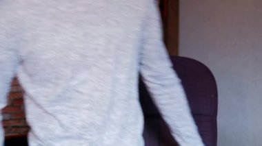 Uzun kollu kazak giyen beyaz erkek öğrenci, salgın durumundan dolayı evde ders çalışıyor.. 
