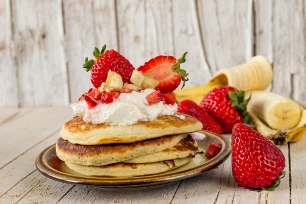 Pfannkuchen mit Sahne, Erdbeeren und Bananen zum Frühstück — Stockfoto