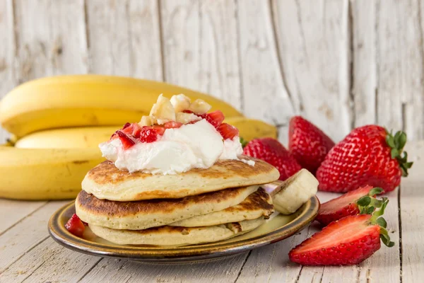 Pfannkuchen mit Sahne, Erdbeeren und Bananen zum Frühstück — Stockfoto
