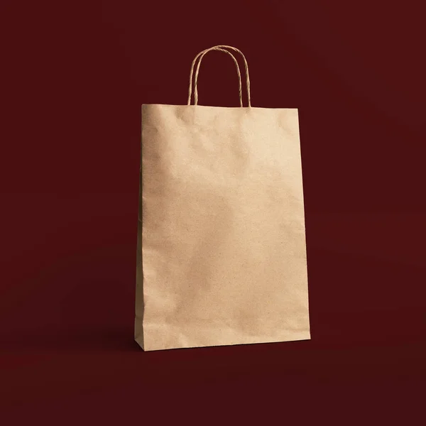 Kırmızı arka planda izole edilmiş, katlanmış kağıt torba.