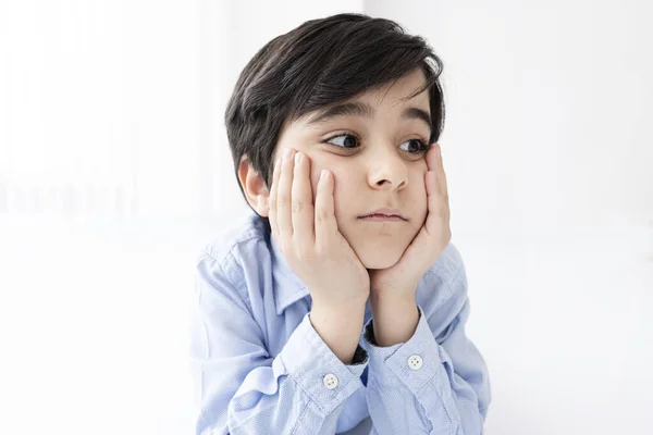 Yüzünde elleri olan küçük bir çocuk.