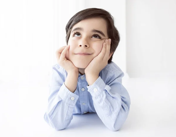 Beyaz arka plan üzerinde düşünen çocuk.