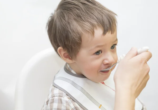 Mother feeding little boy baby food — Stock Photo, Image