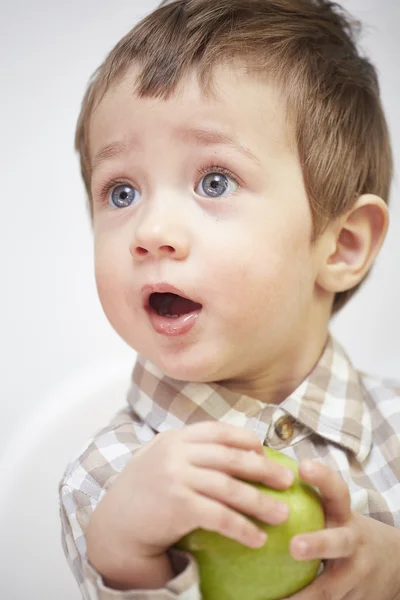 Μικρό αγόρι με ένα μήλο που ψάχνει έκπληκτος — Φωτογραφία Αρχείου