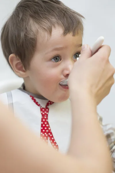 Mother feeding little boy baby food — Stock Photo, Image