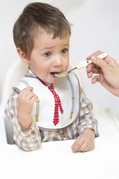 Mother feeding little boy baby food — Stock Photo, Image