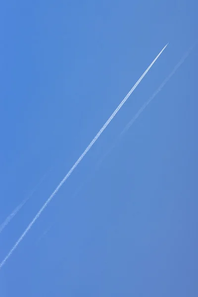 Jälkiä lentokoneesta sinisellä taivaalla — kuvapankkivalokuva