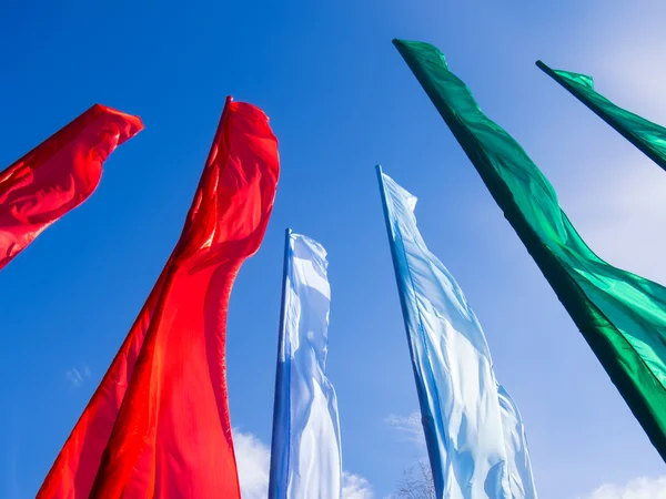 Farverige flag på en blå himmel backgroun - Stock-foto