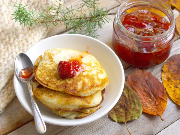 Pancakes and strawberry jam on the wooden table — Stock Photo, Image