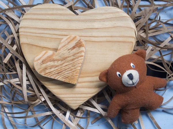 Houten harten en speelgoed dragen over houten tafel Stockfoto