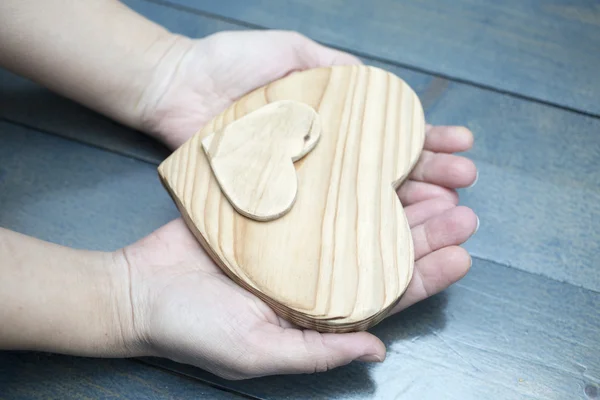 Corazón de madera en manos de mujer —  Fotos de Stock